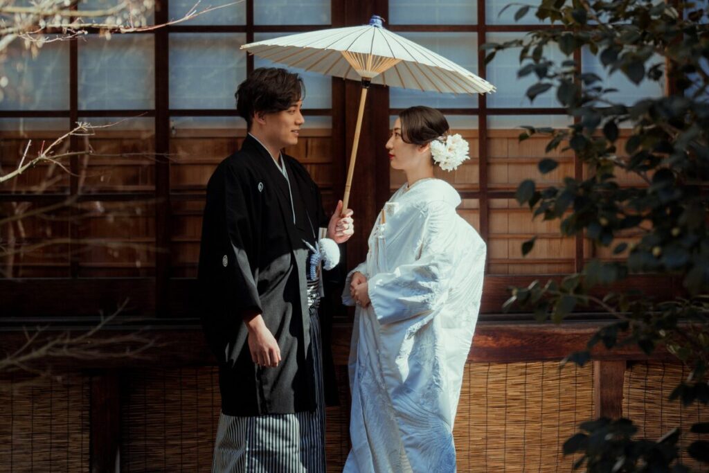 白無垢　向かい合う新郎新婦　洋髪　和傘